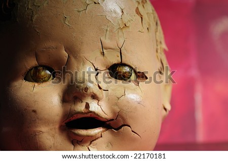 stock photo Creepy old doll head shot against a red textured background