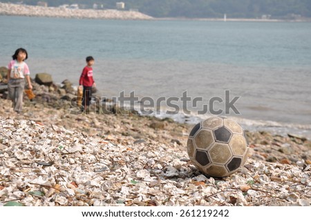HONG KONG -JULY 1: Children playing football on crushed beach,Tai O on July 1 2012,Hong Kong