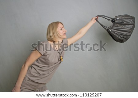portrait of a girl experimenting with leather shoulder bag making happy expression
