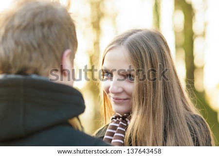closeup up portrait of young female girl looking gently to her opponent\'s eyes standing outside