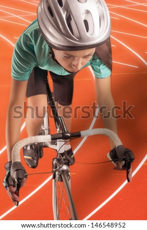 portrait of  woman riding race bike on a track. model equipped with a professional biking gear, uses professional race bike. vertical shot. composite image