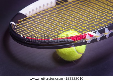 Tennis Concepts: Tennis Racket with Tennis Ball on Black background. Horizontal image