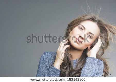 Hair Concept: Sensual Brunette Woman With Fly Away Hair. Over Gray Background. Horizontal Image