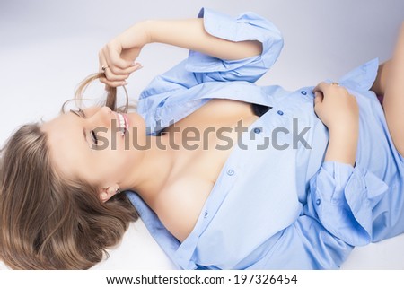 Sexy Playful Caucasian Blond Woman in Nice Blue Shirt Lying on Floor. Horizontal Composition