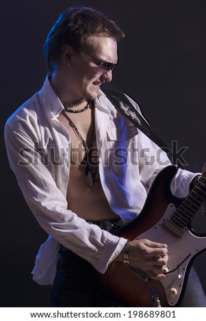 Portrait of Young Male Guitarist Player Playing the Guitar with Expression. Vertical Image