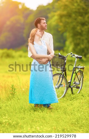 Romantic Young Caucasian Couple Having Romantic Time Together in the Park with Bicycle. Vertical Image