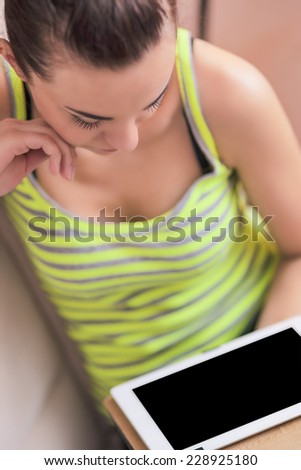 Portrait of Tranquile Caucasian Woman Using Tablet Device in Home Environment. Vertical Image
