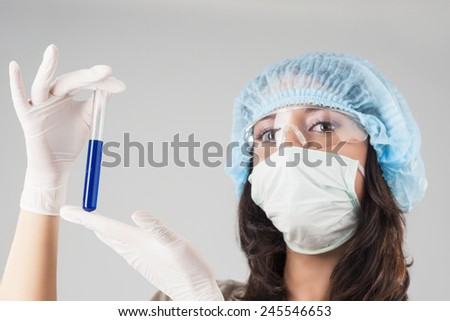Female Laboratory Staff Hands With Test Tube With Liquid and Analyzing.Against Gray Background. Horizontal Image Composition