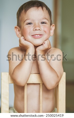 Happy Smiling Little Caucasian Tanned Boy With Hands LIfted. Touching Face. Vertical Image