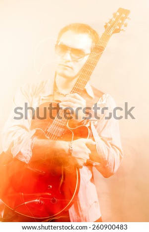 Guitarist With the Acoustic Guitar. Shot with Combination of Strobes and Halogen Light to Create Mood and Atmosphere. Mixture of Flash and Halogen Lights. Vertical Image