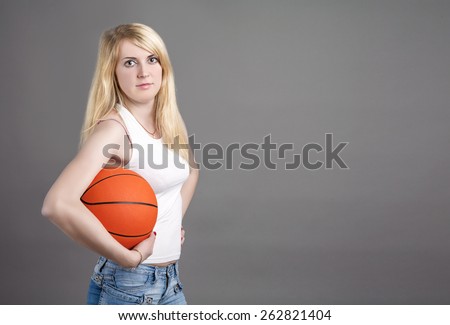 Portrait of Young Caucasian Blond Female  Posing in Studio with Basketball Ball. Horizontal Image Composition