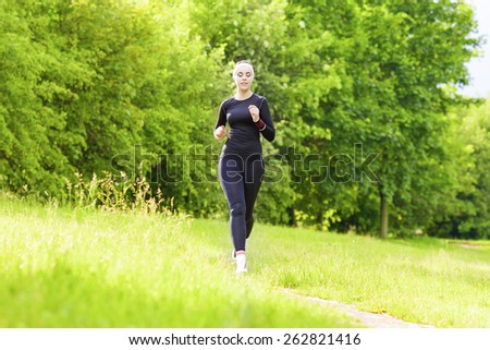 Jogging Concept: Caucasian Fit Woman Having Her Jogging Training Outside in Forest. Horizontal Image Composition