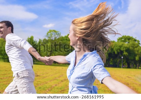 Youth Lifestyle: Caucasian Couple Relaxing Outdoors. Man Dragging Her Lady by Hands.  Holiday and Vacation Concepts. Horizontal Image Composition