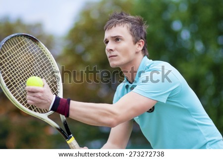 Sport and Tennis Concept: Handsome Caucasian Man With Tennis Raquet Preparing to Serve Ball On Court. Horizontal image