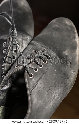 Closeup Shot of Pair of Worn-out Latin Ballroom Dance Shoes. Against Black Background. Vertical Image Orientation