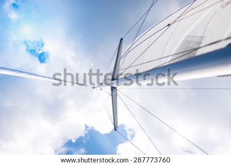 Traveling Concepts: Closeup View of Mid-Size Yacht Mast and Canvas Sail Shot Against Bright Summer Sun. Horizontal Image Orientation