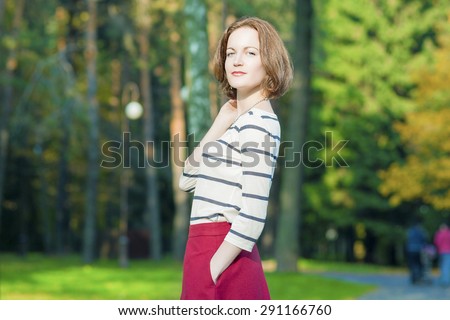 Dreaming Caucasian Brunette Woman in Fashion Clothing Posing in Fall Forest Outdoors.Horizontal Image Orientation