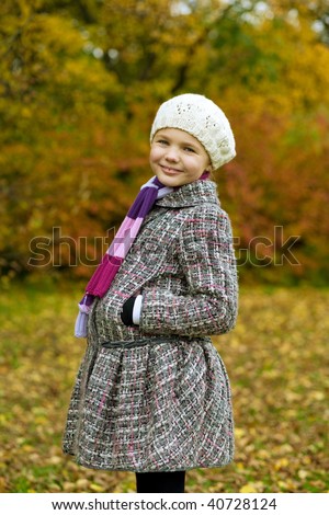 pretty young smiling girl in white autumn beret standing turned left