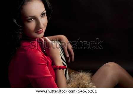 cute and nice beautiful caucasian girl with gentle calm look sitting in chair and holding hand near collar looking appear and isolated over black background