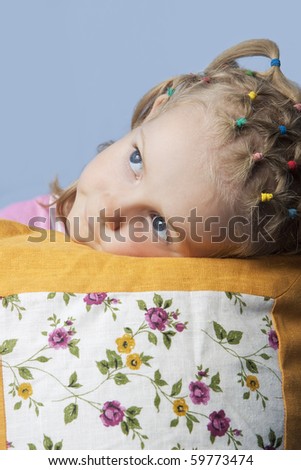 cute caucasian blond little girl preparing to go to sleep having her decorated pillow near and looking appear with calm look isolated