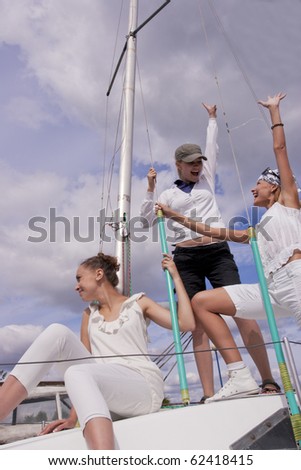 happy three girls standing on yacht and having fun and good time together. shot is made with studio flash on location.