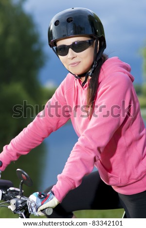 happy and smiling young girl in black helmet standing with bike in front of blue skies,SDF with flash light