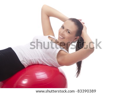 young caucasian girl exercising with fitball having positive facial expression, isolated