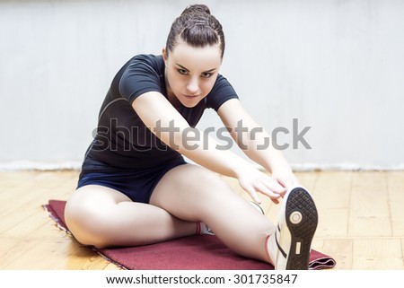 Sport Ideas and Concepts. Fit Woman Stretching Her Leg to Warm Up  Mussels.Horizontal Image Orientation