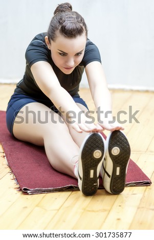 Sport and Fitness Ideas and Concepts. Portrait of Happy Young Woman Doing Stretching Exercise in Gym. Vertical Image