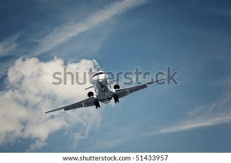 passenger private jet landing on a clear blue sky
