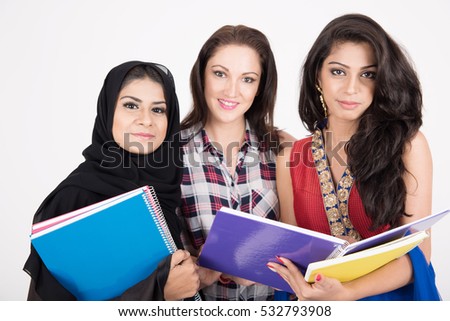 Female students in traditional dresses from different cultures on white background