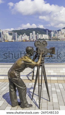 Hong Kong, China May 24, 2013: The filmmaker statue on the Avenue of Stars with the Hong Kong skyline in the background.