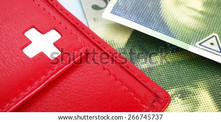 Swiss francs banknotes and red wallet with Swiss flag