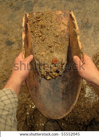 Gold panning with old wooden pan