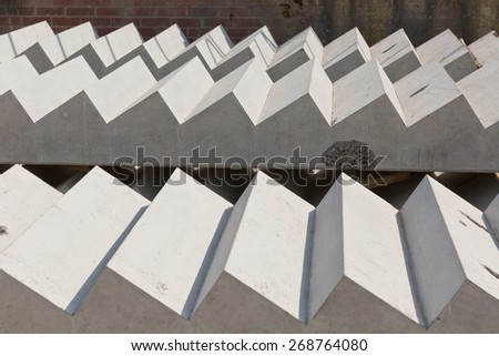 Tow concrete stairs lay flat outdoors against a brick wall