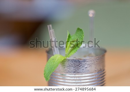 A mojito with mint leaves in a can without the label on