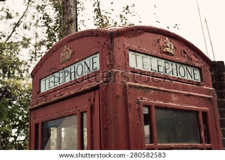 A cropped photo of a british red unused telephone booth with an applied vintage filter