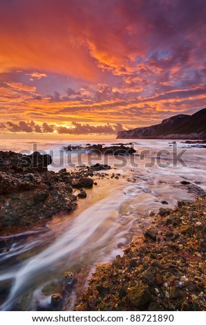 dramatic sunrise with cloudy sky and flowing water in vertical format