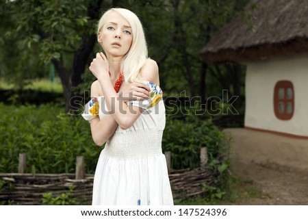 21 Mpix full-frame HD-capture. Professionally retouched. Rural woman standing by old traditional Ukrainian house