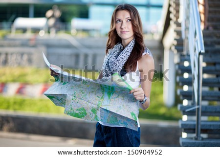 young woman tourist holding paper map outdoors