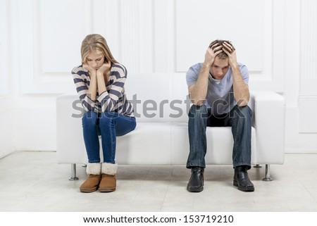 young caucasian couple sitting on couch - family problems