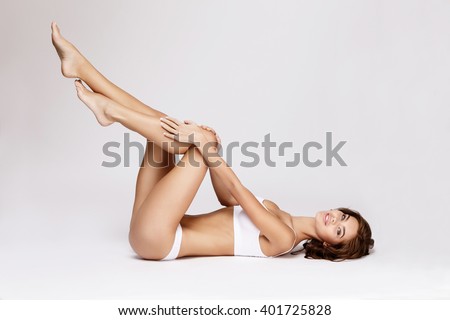 Slim tanned woman's body over gray background