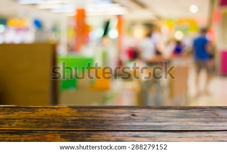 Look out from the table to see  food court in the mall background scene.