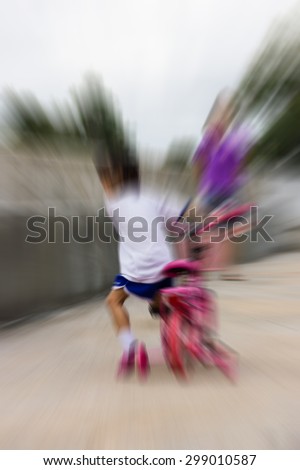 Blur image of children learn to ride a bike with fear.