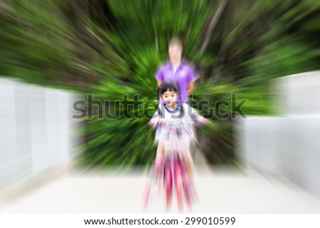 Blur image of children learn to ride a bike with fear.