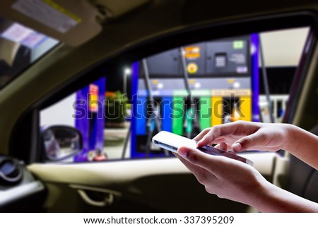 Women use smart phone in the car at gas stations.
