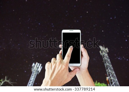 Man use smart phone , blur image of telephone pole as a background.