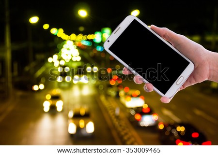 Girl use mobile phone ,blur image of lights from cars at night on the road as background.