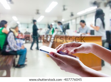 Man use mobile phone, blur image inside hospital as background.