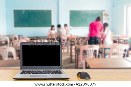 Notebook computer on the table, blur image parents of students and teachers are meeting as background.